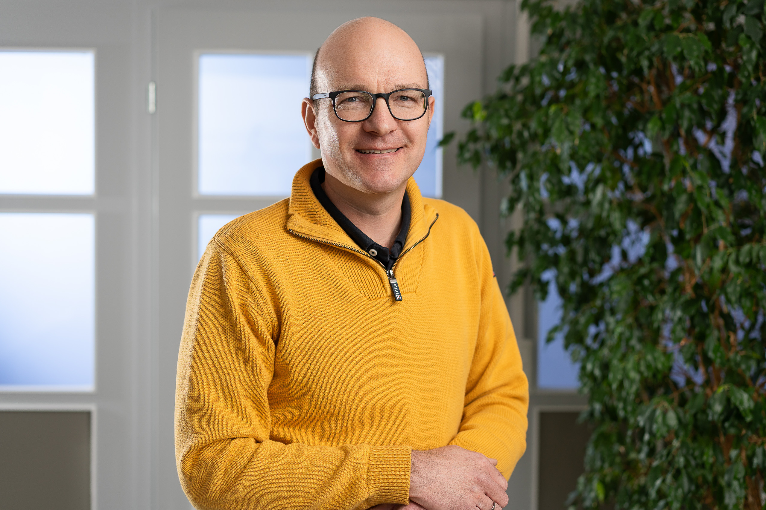 Businessfotografie Hannover: Business-Portrait eines SOCON-Mitarbeiters im gelben Pullover